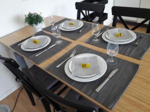 una mesa de madera con platos y copas de vino. en Wydhof Ferienwohnung, en Flaach