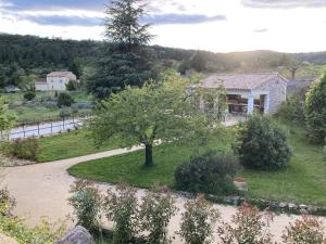 a tree in the middle of a yard with a house at Chambre d'hôtes Lavande- A l'Ombre des Tilleuls in Lagorce