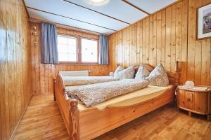 ein Schlafzimmer mit einem Bett in einer Holzwand in der Unterkunft Hof Stein Schwellbrunn in Schwellbrunn