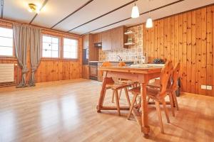 eine große Küche mit einem Holztisch und Stühlen in der Unterkunft Hof Stein Schwellbrunn in Schwellbrunn