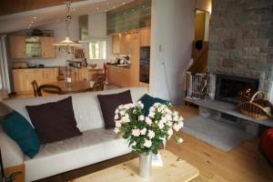 a living room with a white couch and a fireplace at Ferienhaus Befang 17 in Wildhaus