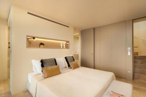 a bedroom with a white bed and a mirror at Palmares Signature Apartments in Lagos