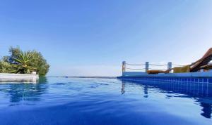 a swimming pool with blue water and a slide at Varandas do Vale Furnazinhas in Castro Marim