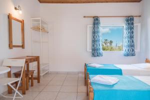 a room with two beds and a table and a window at Seaside Studios in Kavos