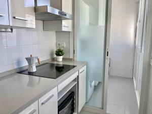 Kuchyňa alebo kuchynka v ubytovaní ÁTICO VALDELAGRANA PLAYA - Aire Acondicionado y Piscina
