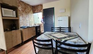 a kitchen with a table and chairs and a kitchen with a refrigerator at 300m-da Av das Cataratas- Ar Condicionado - Estacionamento Privado in Foz do Iguaçu