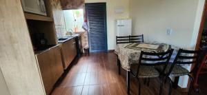 a kitchen with a table and chairs and a refrigerator at 300m-da Av das Cataratas- Ar Condicionado - Estacionamento Privado in Foz do Iguaçu