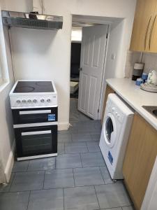 a kitchen with a stove and a washing machine at Homey Flat in Tooting in London