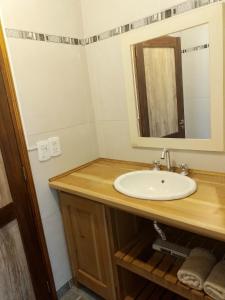 a bathroom with a sink and a mirror at Aparts chalet Alquimia in Lago Puelo