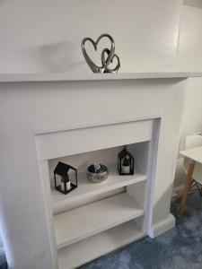 a white fireplace with a heart on top of it at Homey Flat in Tooting in London