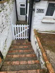 a stairway leading to a house with a white gate at Homey Flat in Tooting in London