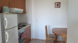 a kitchen with a white refrigerator and a table at Апартамент Blue sky in Sinemorets