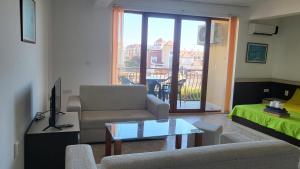 salon z kanapą i stołem w obiekcie Апартамент Blue sky w mieście Sinemorec