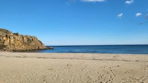 una playa con huellas en la arena y el océano en Апартамент Blue sky, en Sinemorets