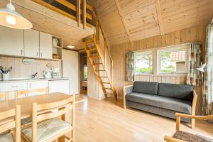 a kitchen and a living room with a couch and a table at First Camp Bogense Strand Camping & Cottages in Bogense