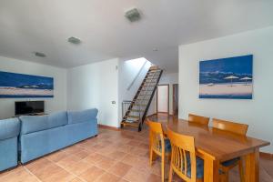 sala de estar con mesa y sofá azul en Villa Alba, en Playa Blanca