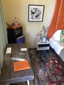 een slaapkamer met een bed en een tafel met een laptop erop bij The Fred - Adults only Hotel in Frederiksted