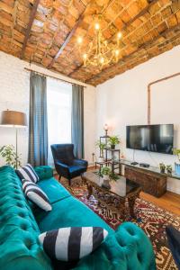 a living room with a green couch and a tv at By Galata- Historical and Modern Apartment in Istanbul
