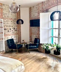 a bedroom with chairs and a table and a brick wall at Hostal Albany Ancha in León