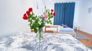 a vase of red flowers sitting on a table at City Centre Synagogue Residential Apartment Budapest in Budapest