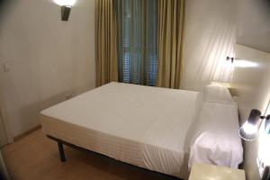 a bedroom with a white bed and a window at Apartaments Sant Jordi Fontanella in Barcelona