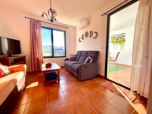 TV a/nebo společenská místnost v ubytování Apartamentos Axarquia , Frigiliana, terraza privada con vistas a la montaña rio y al mar