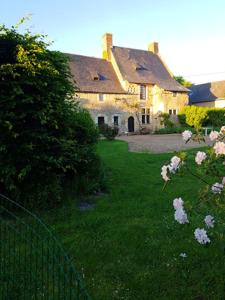 uma casa com um quintal com uma cerca e flores em Maison de 5 chambres avec jardin clos et wifi a Morannes sur Sarthe 