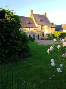 a house with a yard with a fence and flowers at Maison spacieuse avec jardin à Morannes sur Sarthe in Saint-Germain