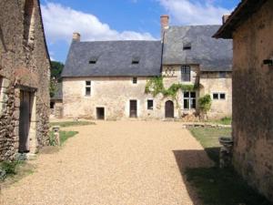 um grande edifício de pedra com um grande pátio em Maison de 5 chambres avec jardin clos et wifi a Morannes sur Sarthe 