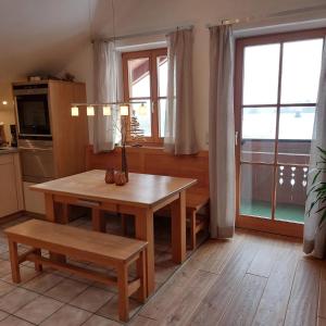 a kitchen with a wooden table and a table and a window at Ferienwohnung Holzmaier in Bad Aibling