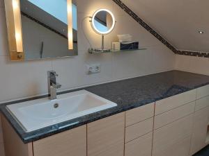 a bathroom with a sink and a mirror at Ferienwohnung Holzmaier in Bad Aibling