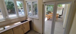 a kitchen with windows and a dining room with a table at Stone House in Pridraga +61 photos
