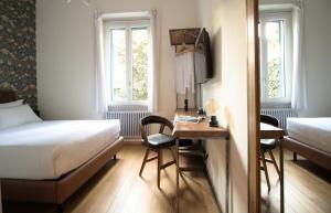 a hotel room with a bed and a desk with a table at Porta Tosa Boutique in Milan