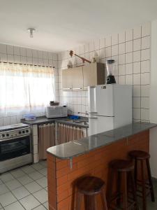 una cocina con encimera y algunos taburetes en ella en Duplex Residencial Santos, en Florianópolis