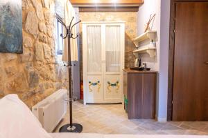 1 dormitorio con puerta blanca y pared de piedra en Lithea mountain resort and spa, en Florina