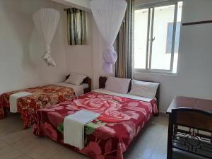 a room with two beds and a window at Kwale Golden Guest House in Kwale