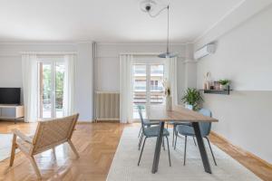 ein Esszimmer und ein Wohnzimmer mit einem Tisch und Stühlen in der Unterkunft Homey 2BR Apartment in Cholargos by UPSTREET in Athen