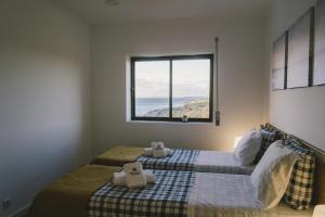 a bedroom with two beds and a window at Best Houses 73 - Lovely view São Bernardino in Atouguia da Baleia