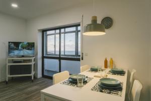 a dining room with a table and a television at Best Houses 73 - Lovely view São Bernardino in Atouguia da Baleia