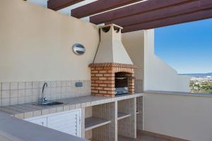 een keuken met een bakstenen oven op het aanrecht bij Casa Saudade - Luxury penthouse apartment with stunning views in Estômbar