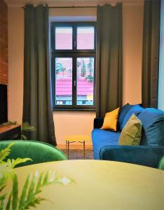 a living room with a blue couch and a window at Central LOFT in Nowe Miasto Lubawskie