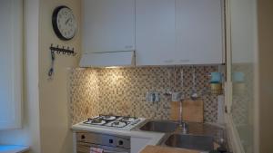 a kitchen with a stove and a clock on the wall at MGPGroup Guest House Piazza Navona in Rome