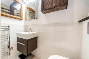 La salle de bains blanche est pourvue d'un lavabo et d'un miroir. dans l'établissement Outstanding Antique 1BR flat in Soho, à Londres