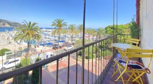a balcony with a yellow chair and a view of a beach at Sablettes Beach-plage-vue mer-centre ville in Menton