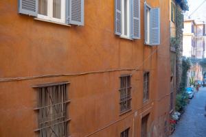 an orange building with windows on a street at MGPGroup Guest House Piazza Navona in Rome
