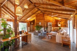 卡尔贾特Anjee's Chalet by StayVista - Mountain-view villa with Classic wooden interiors, Lush lawn & Snooker table的开放式客厅设有木制天花板和家具。