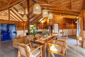卡尔贾特Anjee's Chalet by StayVista - Mountain-view villa with Classic wooden interiors, Lush lawn & Snooker table的配有木桌椅的餐厅