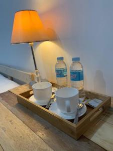 a table with a lamp and two bottles of water at The Tiny Room Apartment Units near Anonas and Cubao in Manila