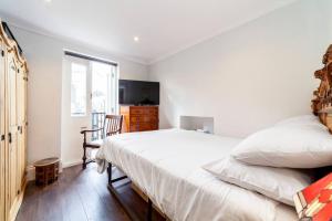 - une chambre avec un lit, une chaise et une fenêtre dans l'établissement Outstanding Antique 1BR flat in Soho, à Londres