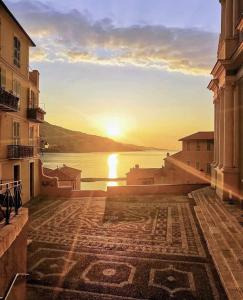 a view of the sunset from a street in a city at Sablettes Beach-plage-vue mer-centre ville in Menton